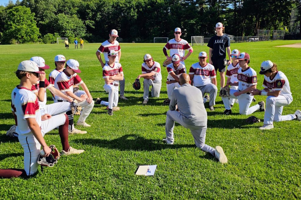 Sharon baseball players in a post-game meeting after a big win